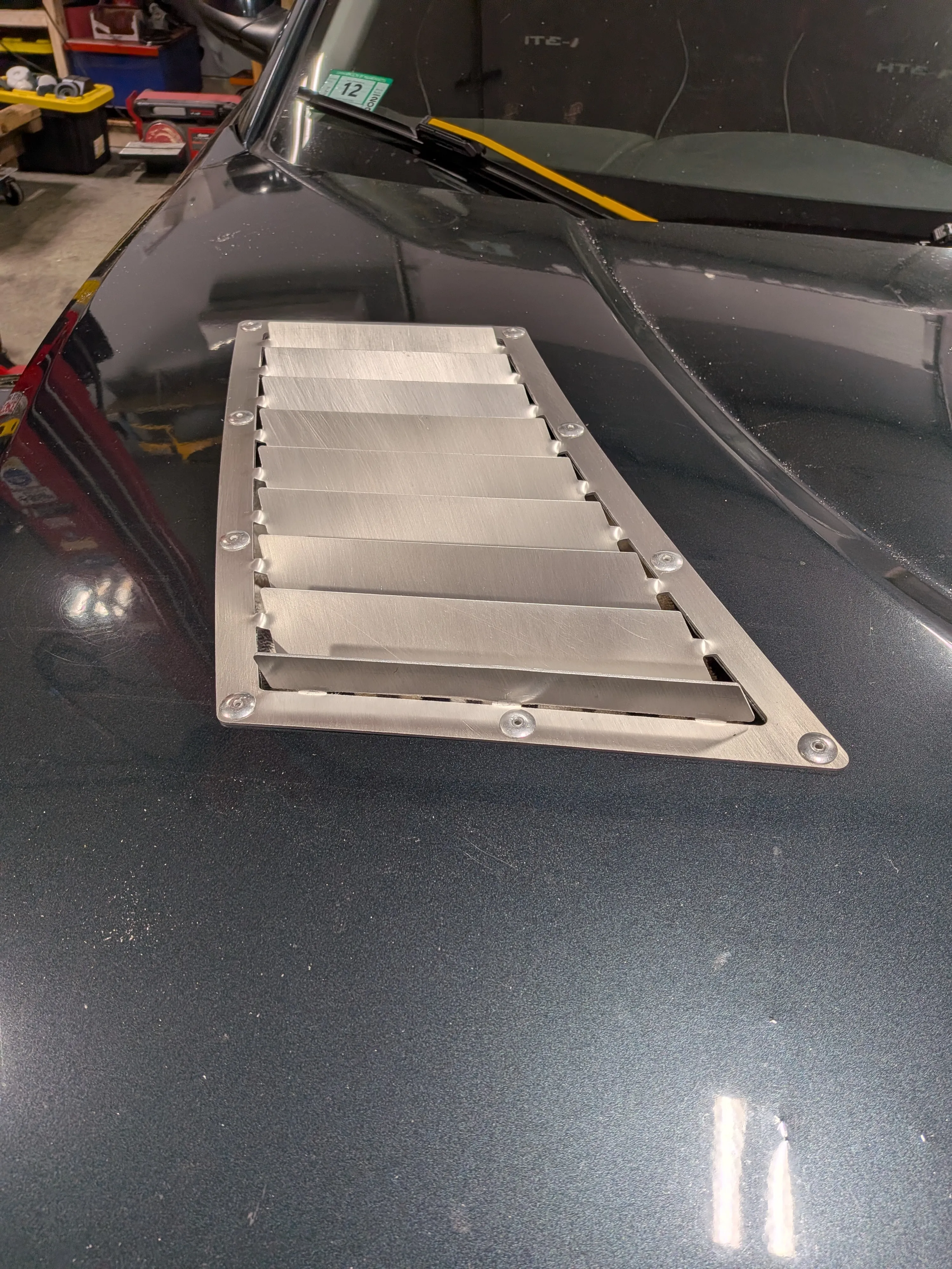 Close-up of an unbent RX8 hood vent showing the louvers